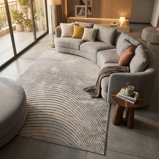 Modern living room with a gray sectional sofa, patterned rug, and side table.